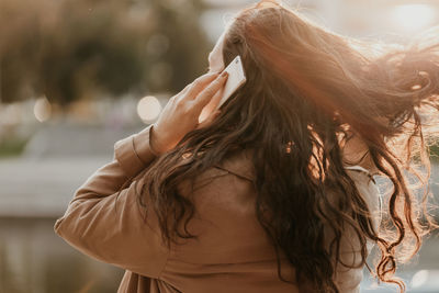 Rear view of woman standing against blurred background