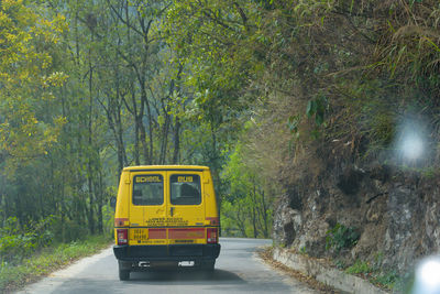 Yellow car on road in forest