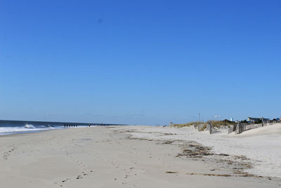Scenic view of beach against clear blue sky