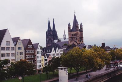 Buildings in city against cloudy sky