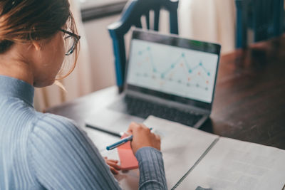 Side view of businesswoman working at table