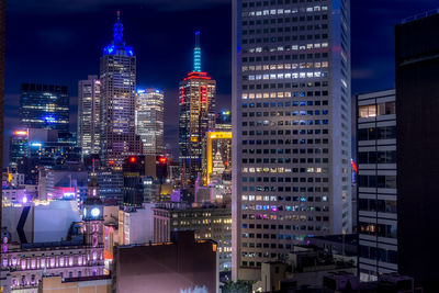 Illuminated buildings in city against sky at night