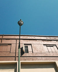 Low angle view of street light against blue sky