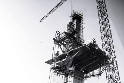 Low angle view of crane against clear sky