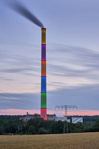 Low angle view of telephone pole on field against sky