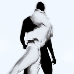 Rear view of man and woman standing against white background