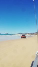 Scenic view of beach against clear blue sky