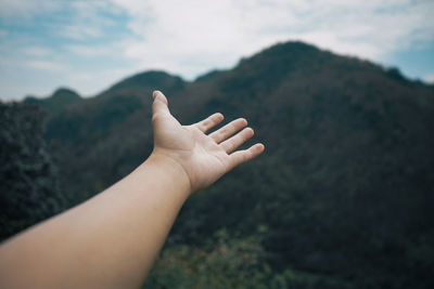 Midsection of person on mountain against sky