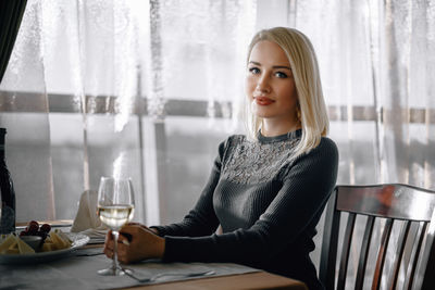 Portrait of young woman sitting on table