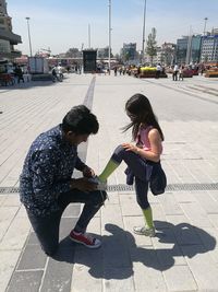 Children playing on sidewalk in city
