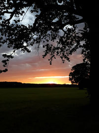 Scenic view of silhouette field against sky during sunset