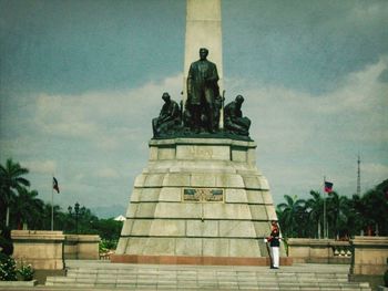 Statue of woman against sky