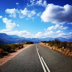 Empty road with mountains in background