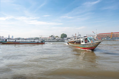 Fishing boats in sea against sky