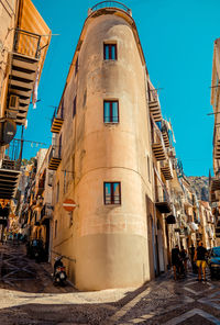 People outside building against blue sky