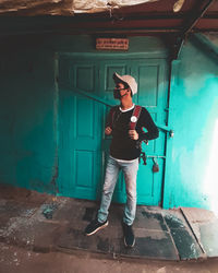 Full length of young man standing against door