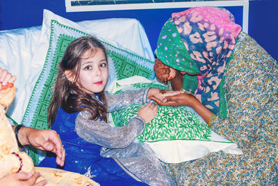 Portrait of girl getting heena tattoo on hand