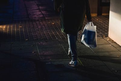 Low section of man walking on sidewalk