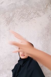 Portrait of boy standing against wall