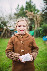 Portrait of a smiling girl holding plant
