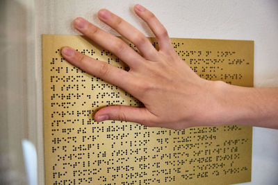 Close-up of hand holding book with text