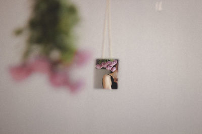 Midsection of woman reflecting on glass against wall