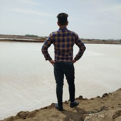 Rear view of man standing on beach