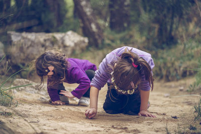 Two little girls playing and heading with the sand. active family holidays with children. 