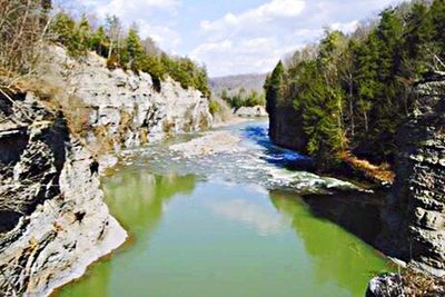 Scenic view of river against cloudy sky