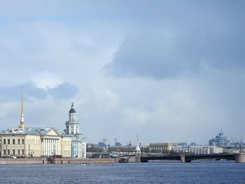 River in city against cloudy sky