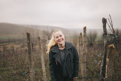 Smiling farm worker wearing jacket at vineyard