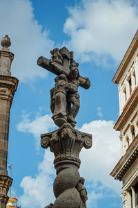 Low angle view of statue of historic building against sky