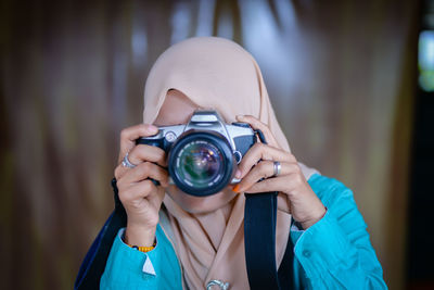 Portrait of woman photographing with camera