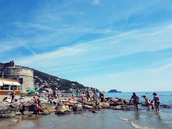 People on beach against blue sky