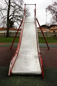 Empty playground in park against sky