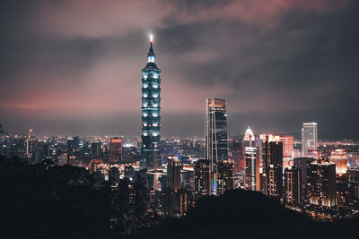 Illuminated cityscape against sky at night