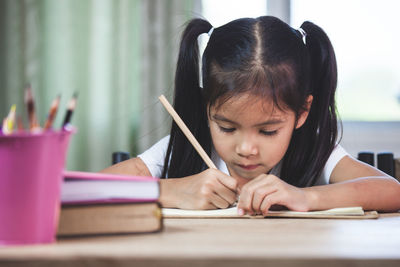 Cute girl studying in classroom at school