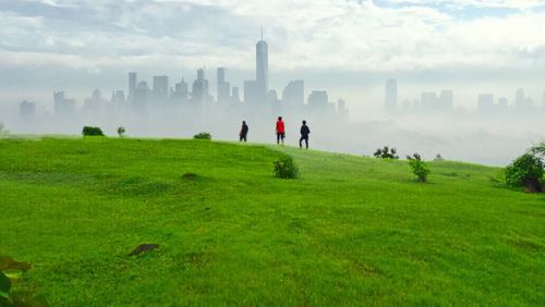 People on field against cloudy sky