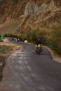 People riding motorcycle on road in city