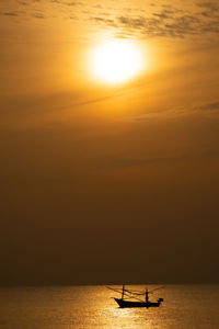 Silhouette boat in sea against sky during sunset