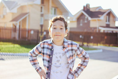 Portrait of boy standing against building