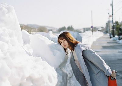 Woman standing on snow covered landscape during winter