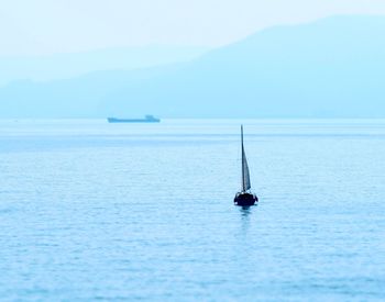 Sailboat sailing on sea against sky