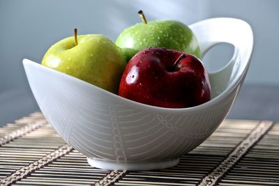 Fresh wet apples in bowl on table