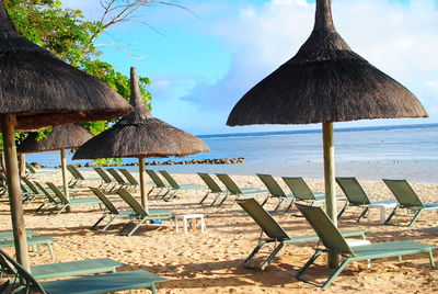 Chairs on beach against sky