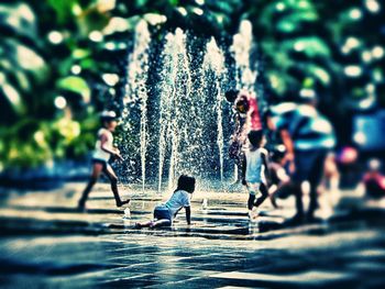 Man and woman walking on fountain in city