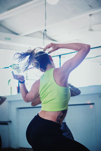 Rear view of woman dancing in gym