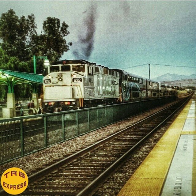 railroad track, rail transportation, public transportation, transportation, railroad station, railroad station platform, train - vehicle, passenger train, train, travel, mode of transport, public transport, railway track, sky, railway station, journey, station, cloud - sky, tree, day