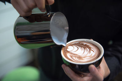 Cropped image of hand holding coffee cup