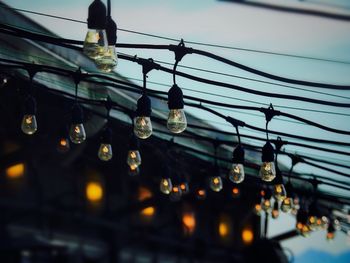 Low angle view of light bulbs against sky